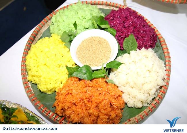 ベトナムの5色こわ飯（Xôi Ngũ Sắc）は、色とりどりの素材を使った蒸しご飯です。ピンク、緑、黄色などの色鮮やかな具材が、甘さと塩気のバランスを楽しませてくれます。